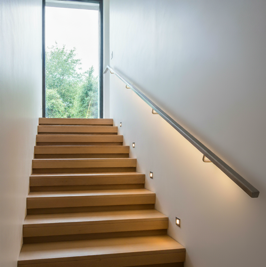 Corrimano in acciaio inox a led con luce calda e montato sul muro lungo una scala interna