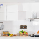 Modern white kitchen with counter and white details, minimalist interior, Full set of kitchen equipment, pan, pot, electric hob, flipper, vegetable, fruit.