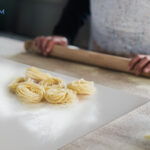 Woman prepare traditional pasta inside italian factory